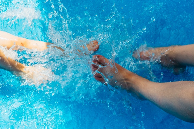 Ľudia si máčajú nohy v bazéne s priezračne čistou vodou.jpg